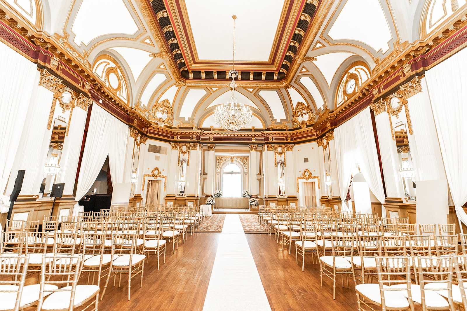 Grand ballroom with gold ceiling and chandelier ceremony