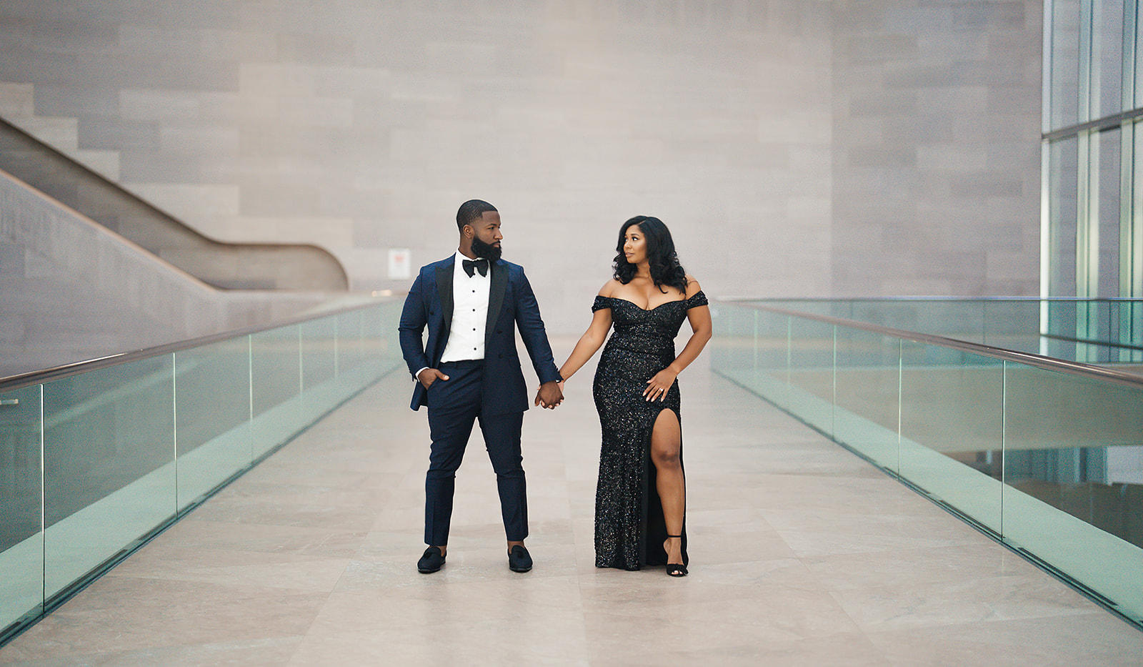 Couple formal portrait on glass walkway at museum