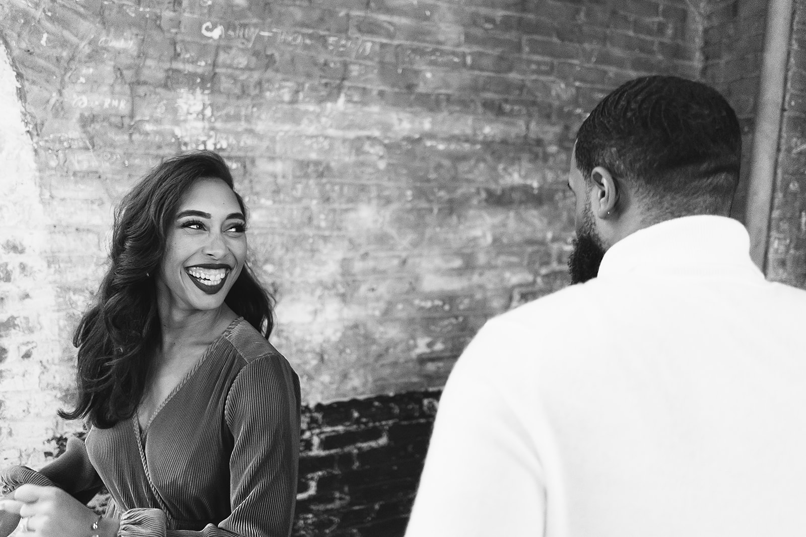 Woman laughing at brick wall black and white candid closeup