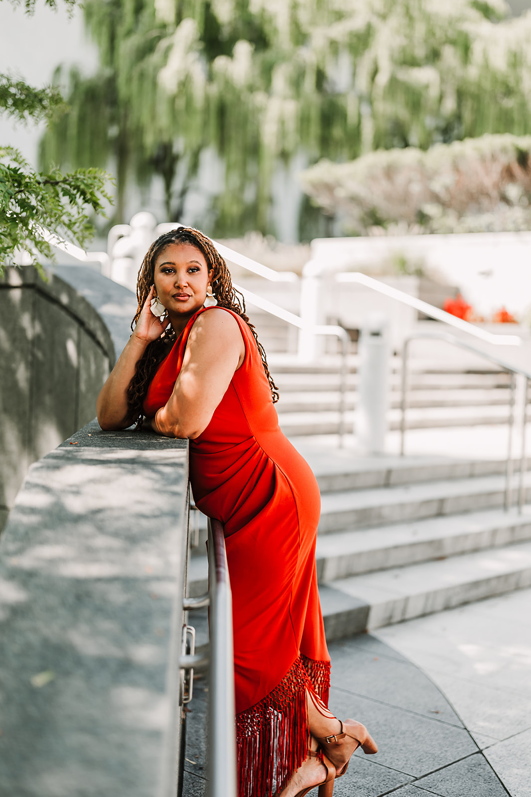 Woman in red fringe dress by railing portrait