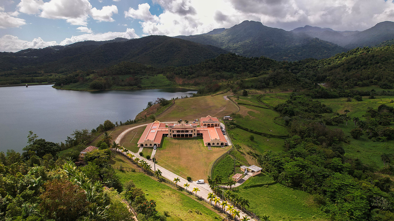 Aerial view of lakeside estate with mountains Los Cabos destination wedding venue