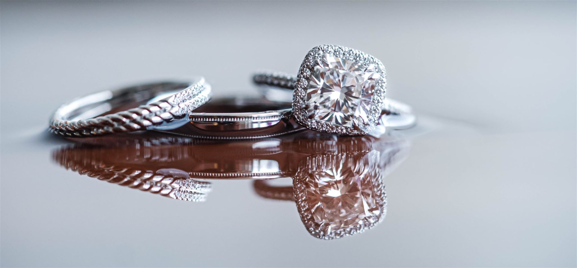 Cushion halo diamond engagement ring with twisted band reflection macro
