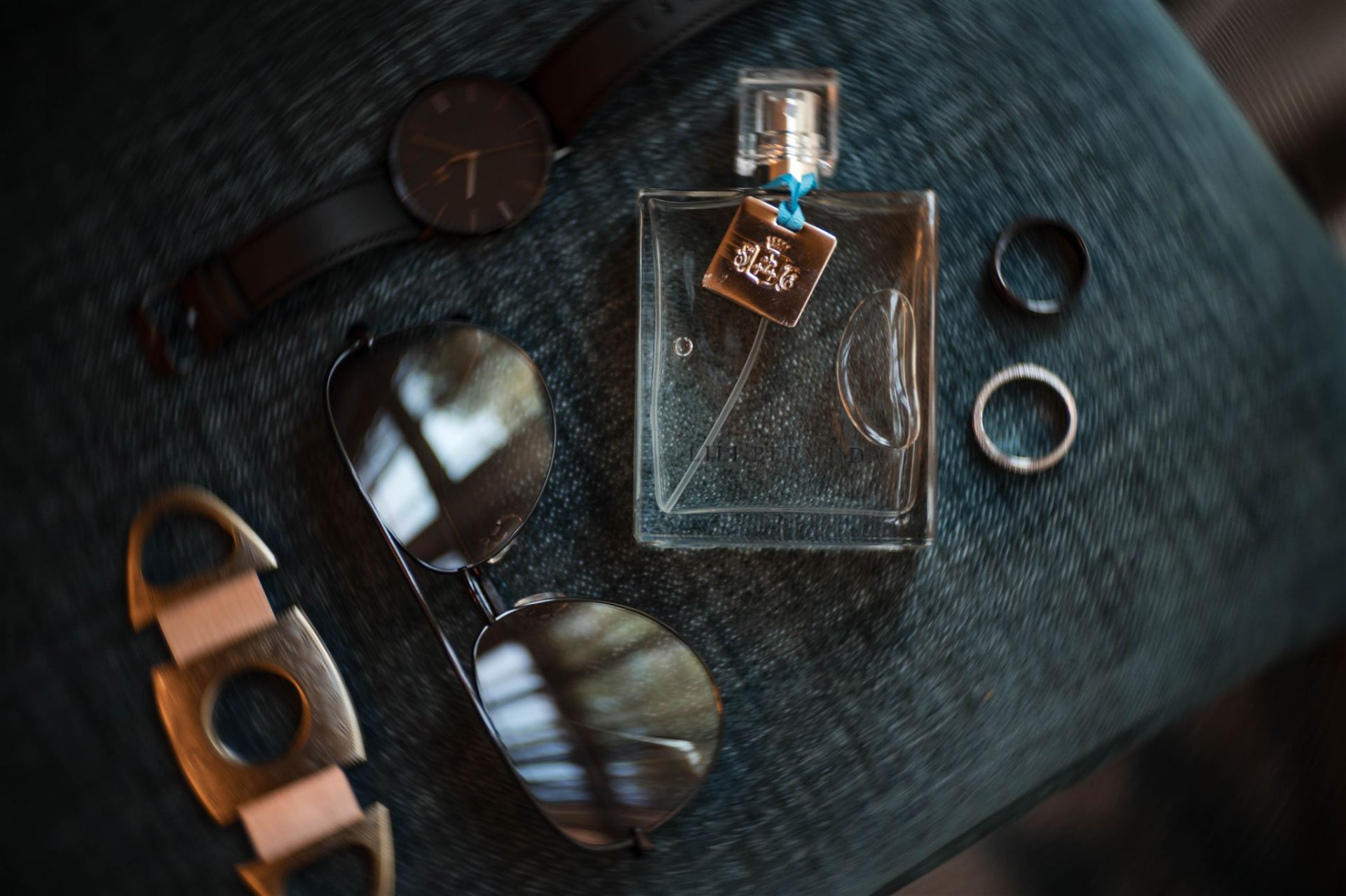 Groom cologne sunglasses watch and rings flatlay detail