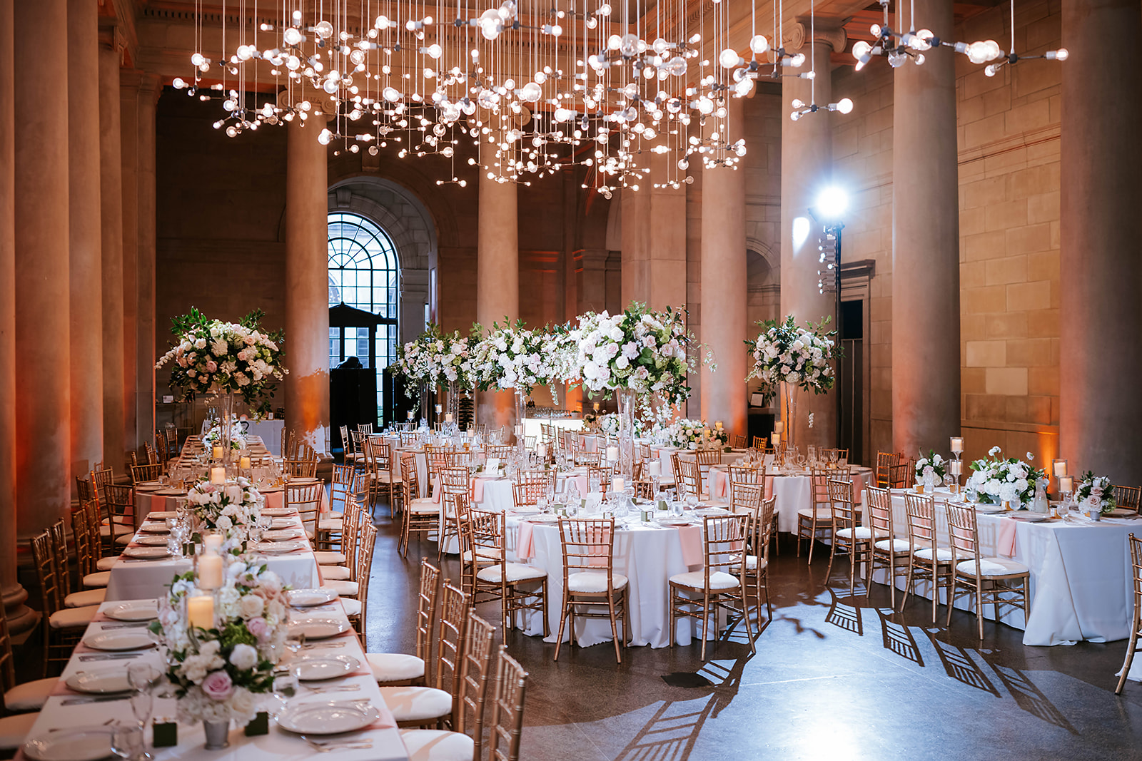 Grand reception hall with columns tall florals and bubble lights