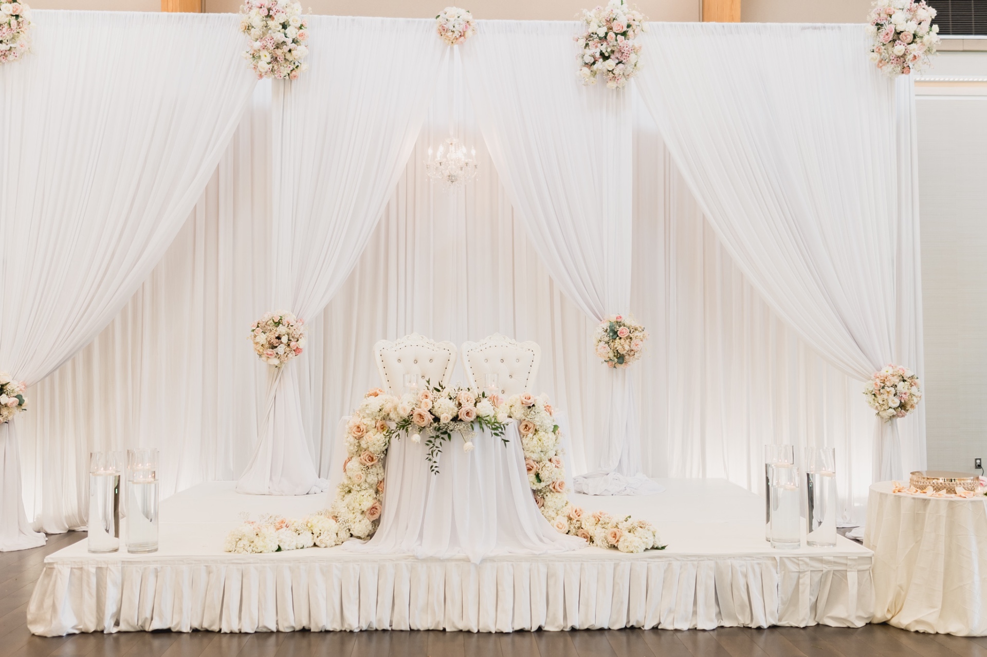 Sweetheart table white draping blush florals chandelier throne chairs