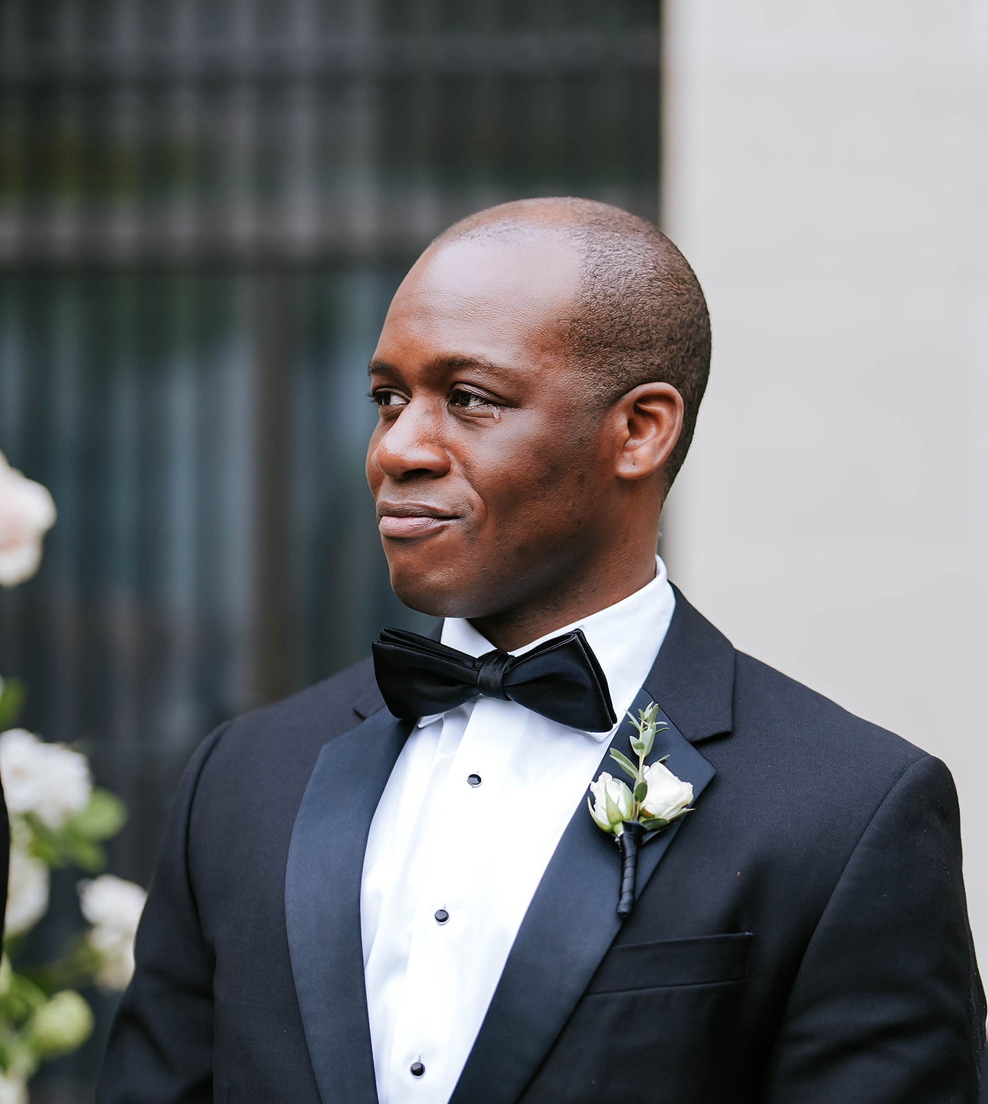 Groom in classic tuxedo with bowtie and boutonniere ceremony portrait