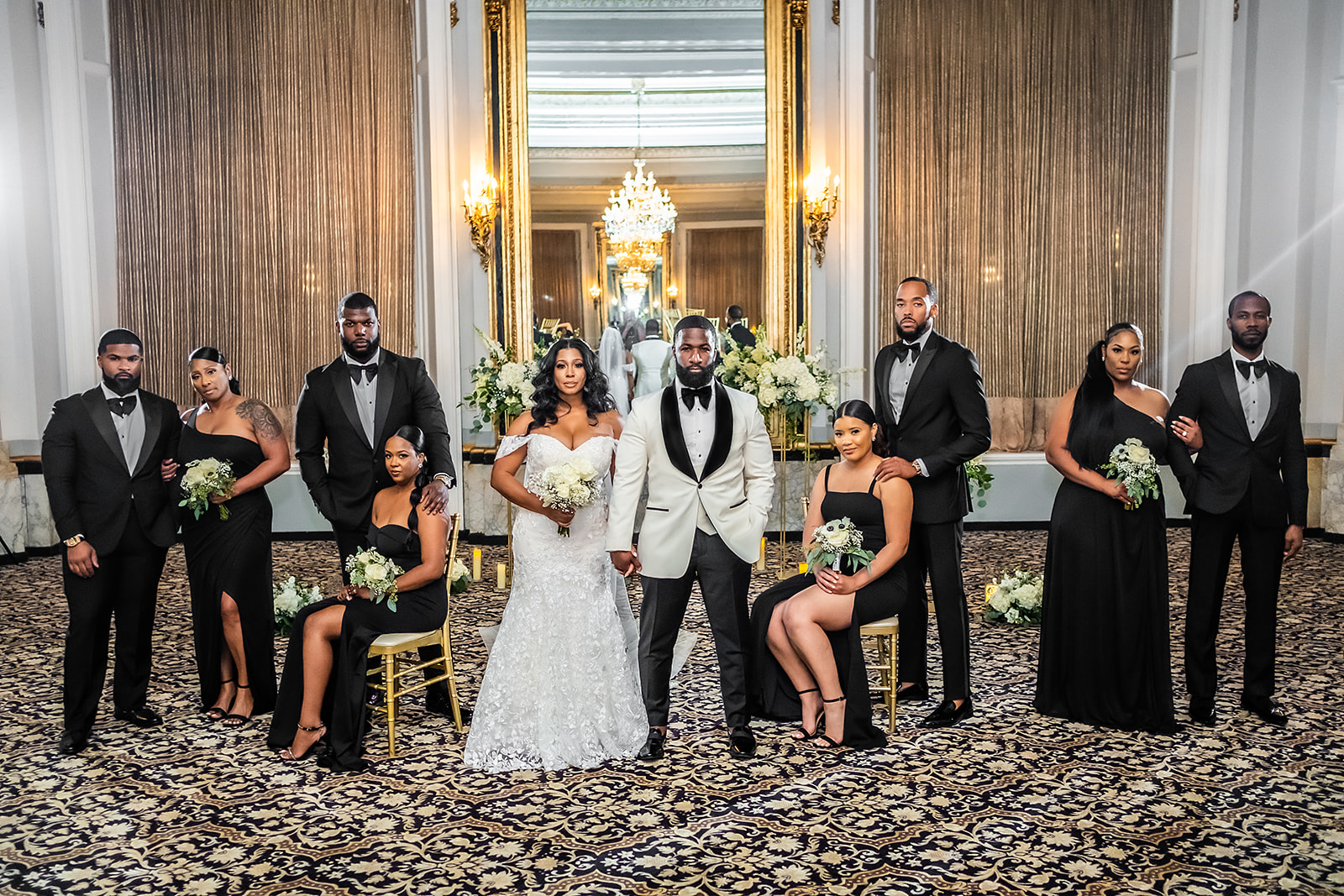 Wedding party in ballroom with gold mirror