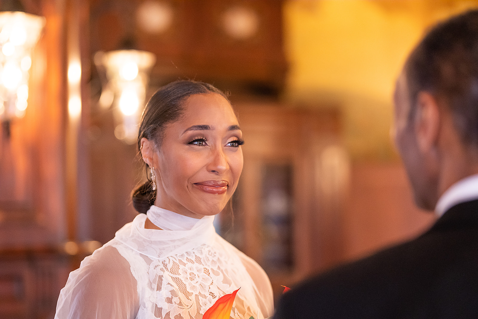 Bride emotional during vows lace gown closeup warm light