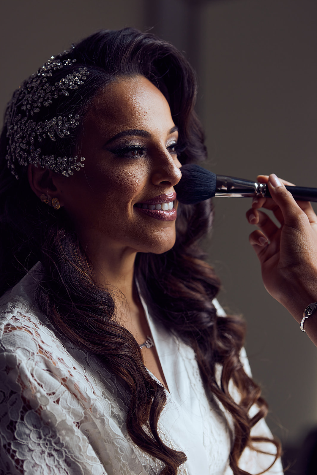 Bride getting makeup with crystal headpiece closeup