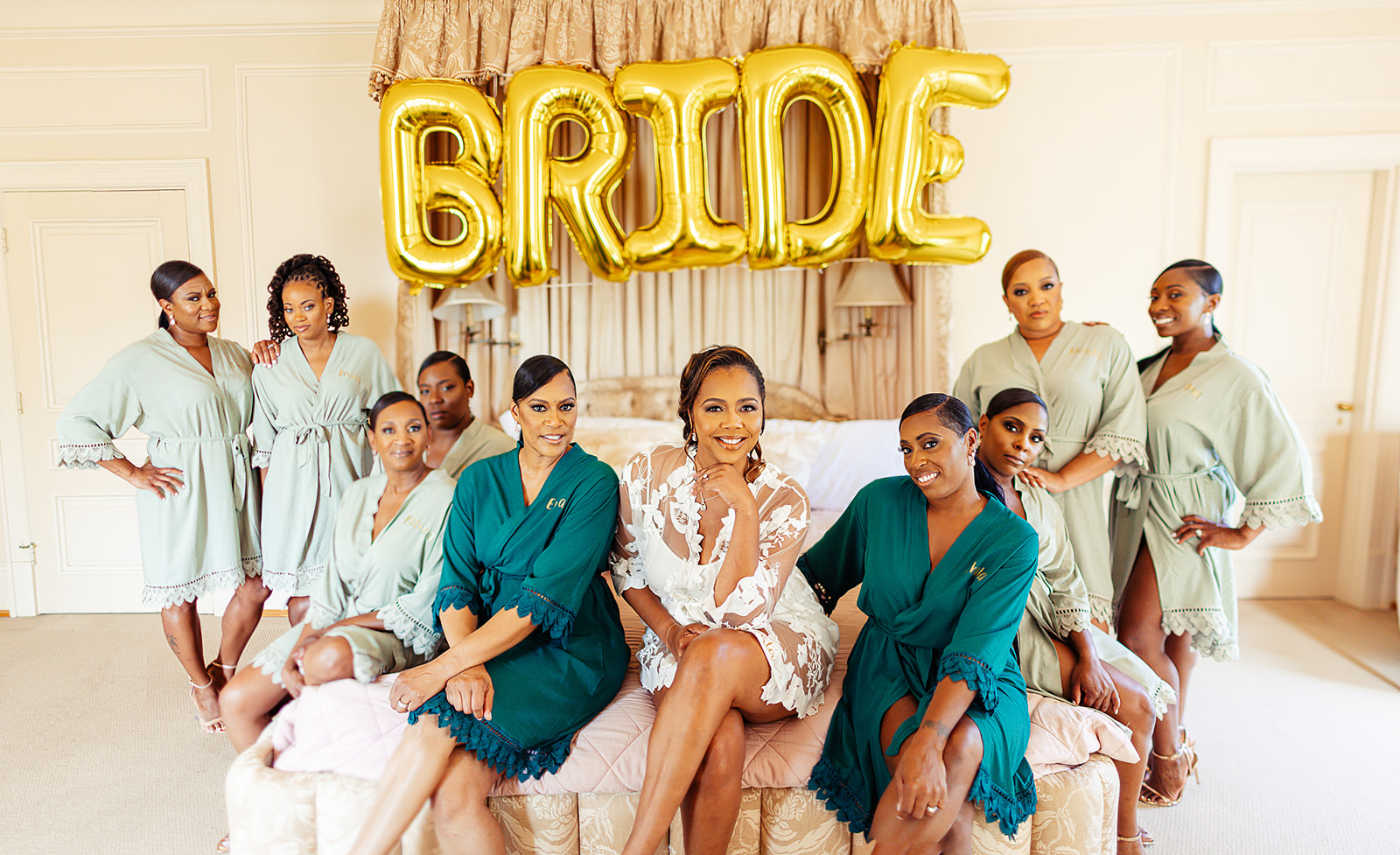 Bridesmaids in green robes with bride and gold balloons getting ready