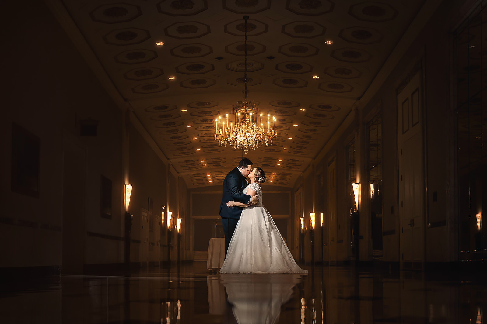 Couple in grand ballroom with chandelier