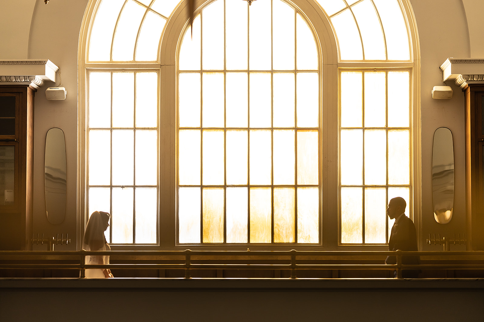 Couple silhouette in arched window with golden light