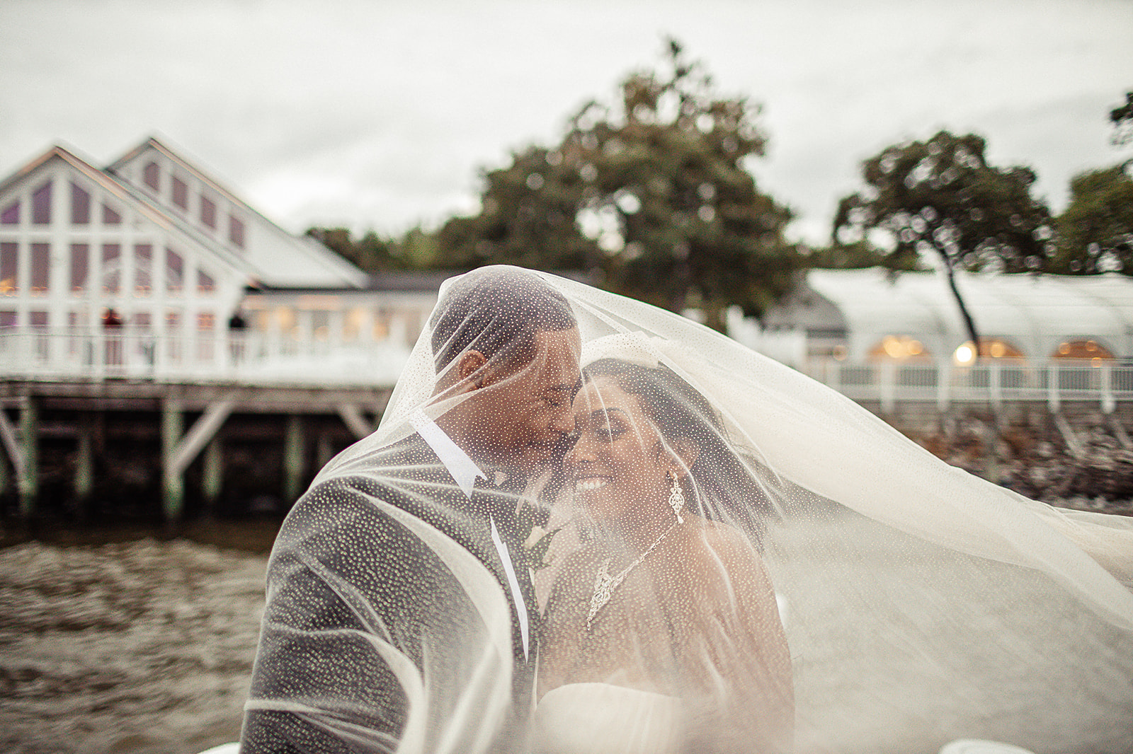 Couple with veil at waterfront venue