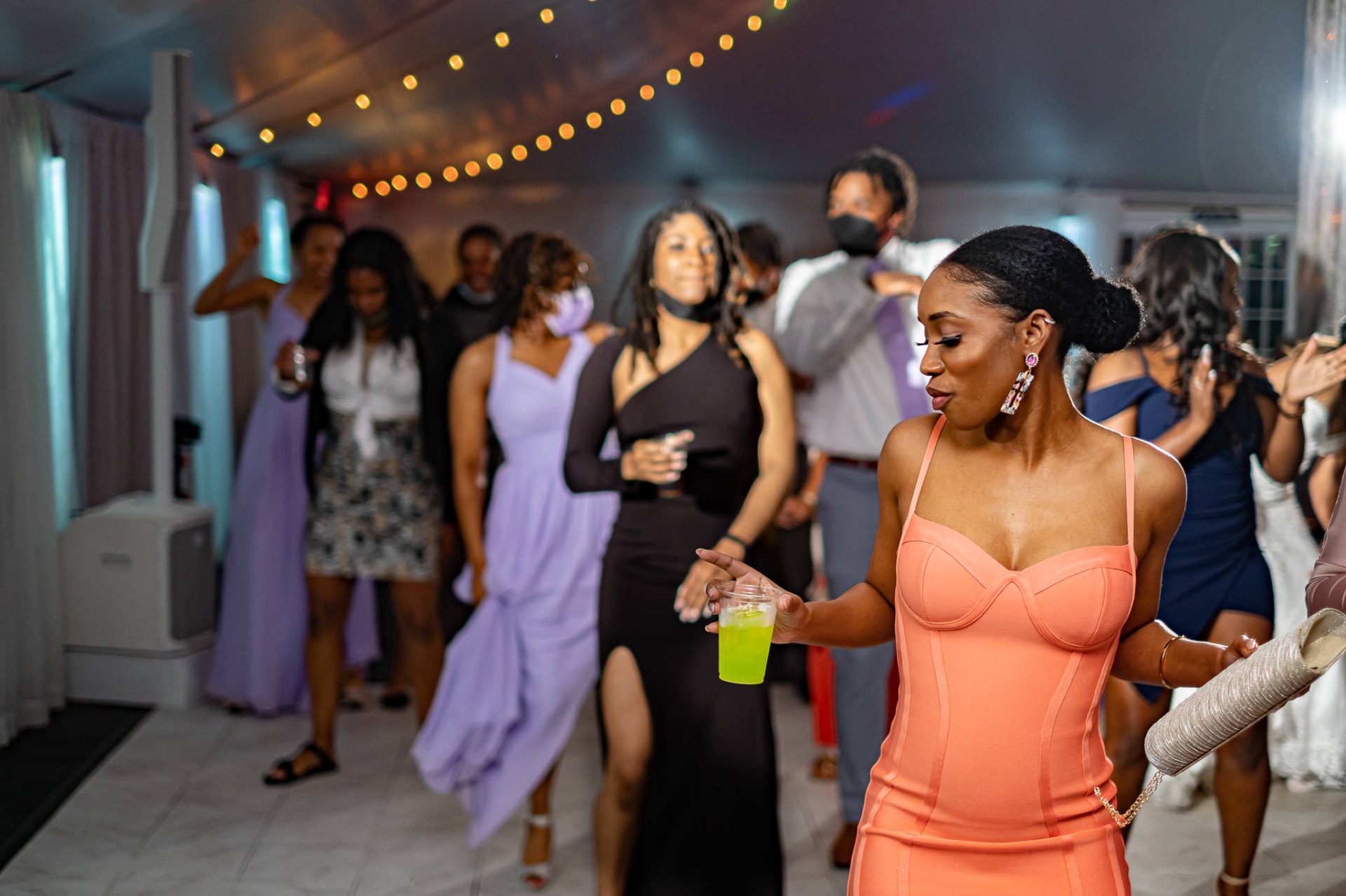 Guest dancing under string lights at reception
