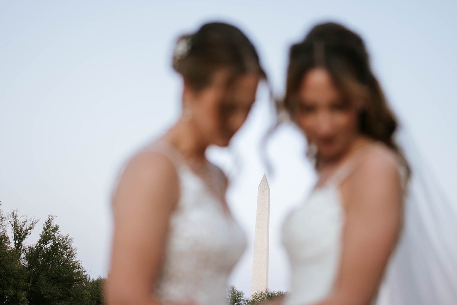 Two brides with Washington Monument in bokeh background